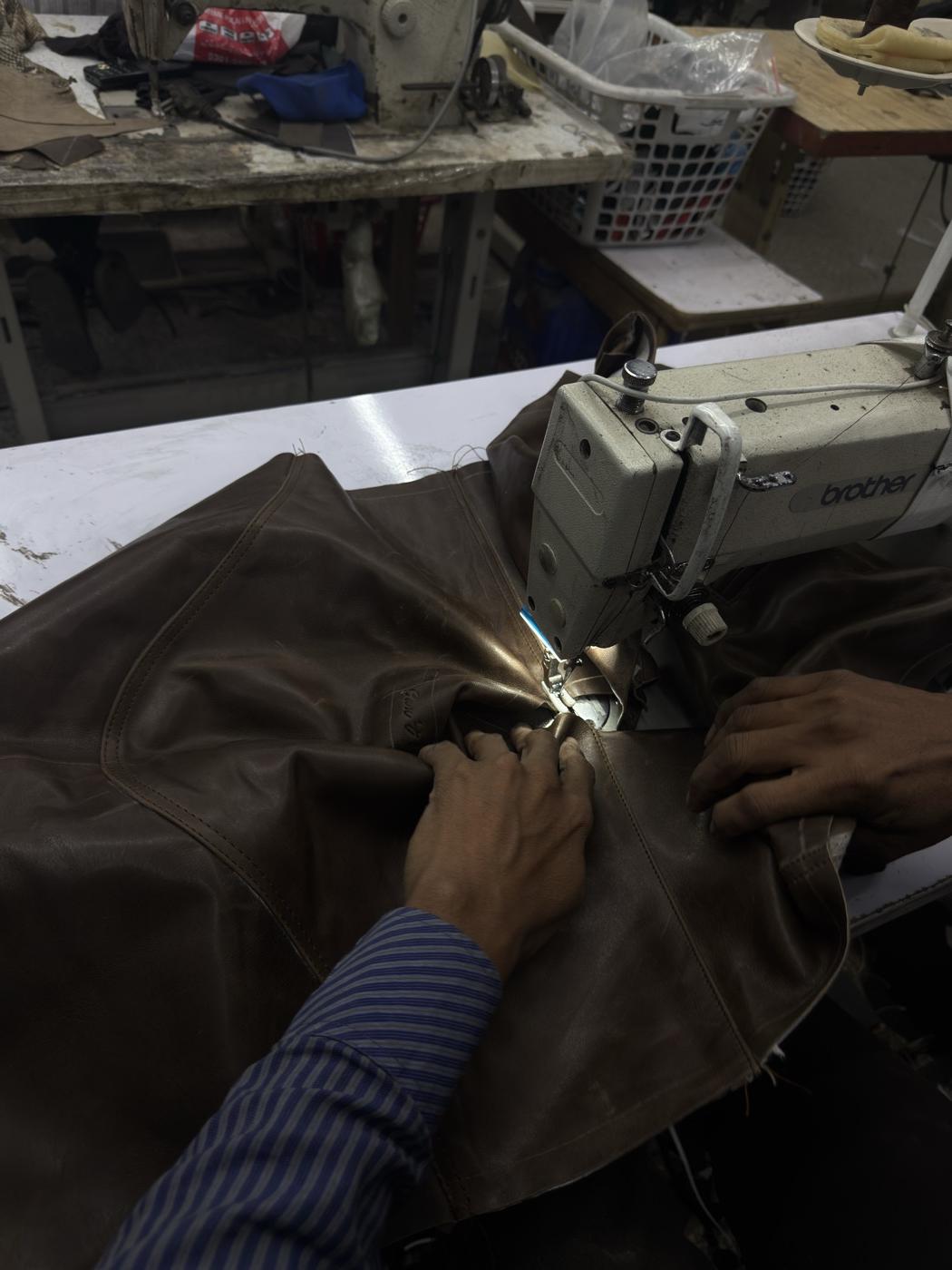 Brown leather jacket being stitched on Brother industrial sewing machine