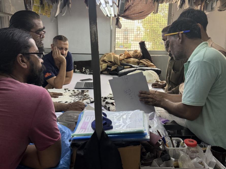 Mac Leather design team reviewing tech pack drawings and leather samples