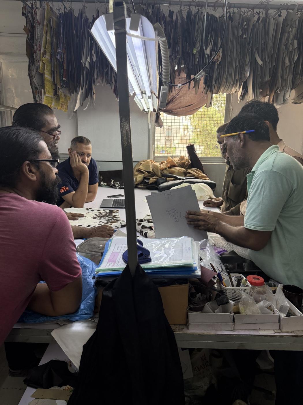 Mac Leather design team reviewing tech pack drawings and leather samples