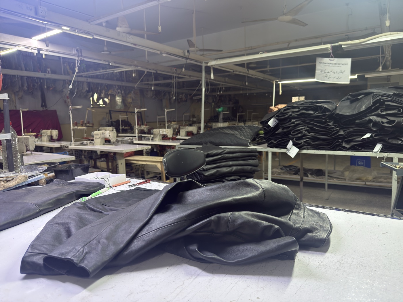 Mac Leather factory floor in Karachi showing finished jackets and sewing stations