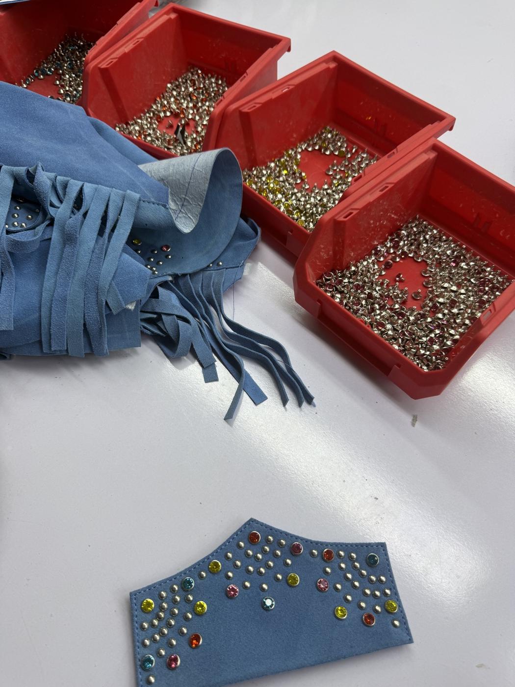 Blue suede leather panel with studs and rhinestones and hardware bins