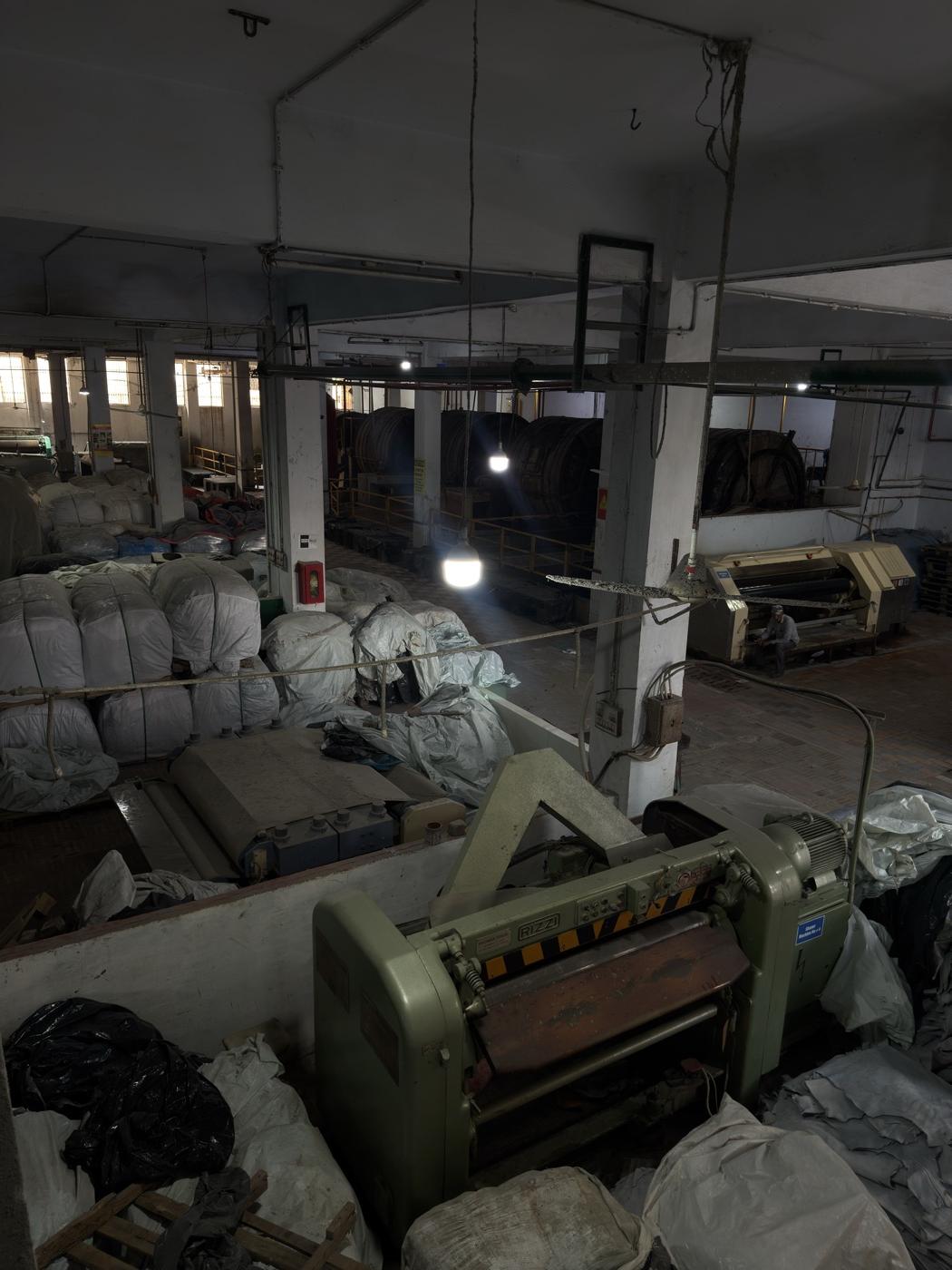 Leather splitting and shaving machines at Korangi tannery with hide bags