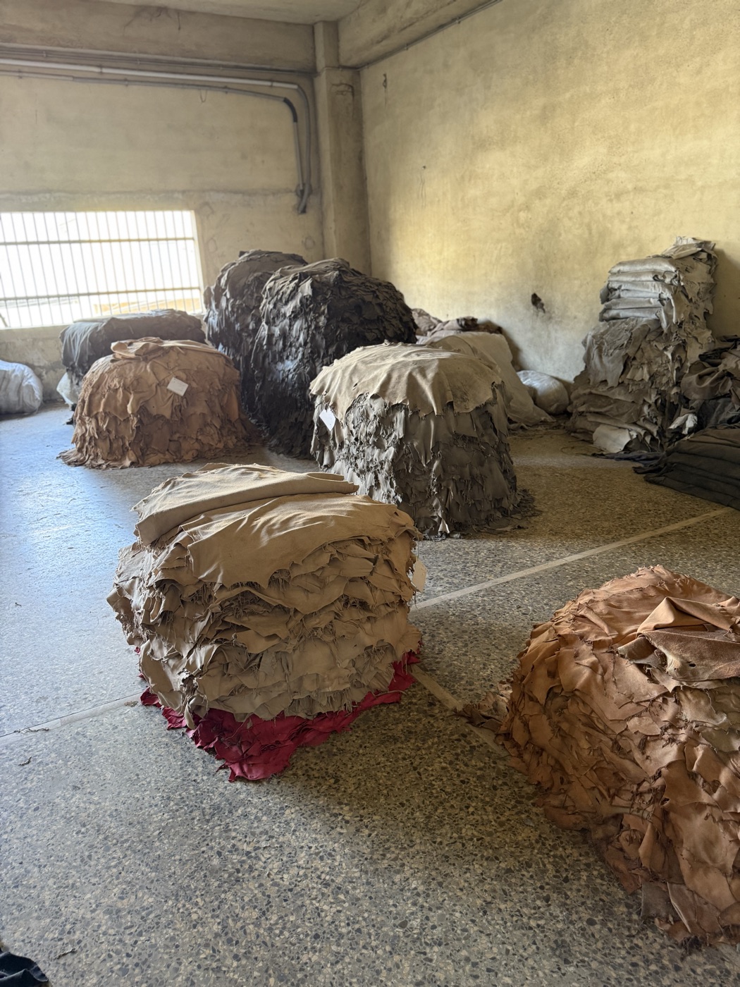 Stacks of dyed leather hides in multiple colours at Karachi tannery warehouse